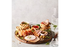 Image Charcuterie board with sliced deli meats, bread, olives, and dips